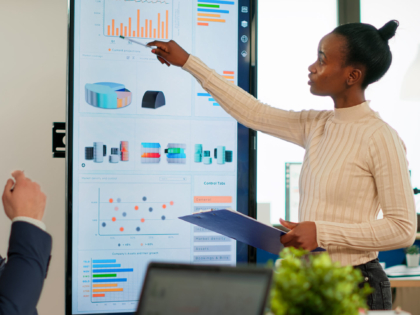 Corporate business people meeting in boardroom, african manager brainstorming with colleagues, discussing strategy, sharing problem, solving ideas collaborating in conference room of company